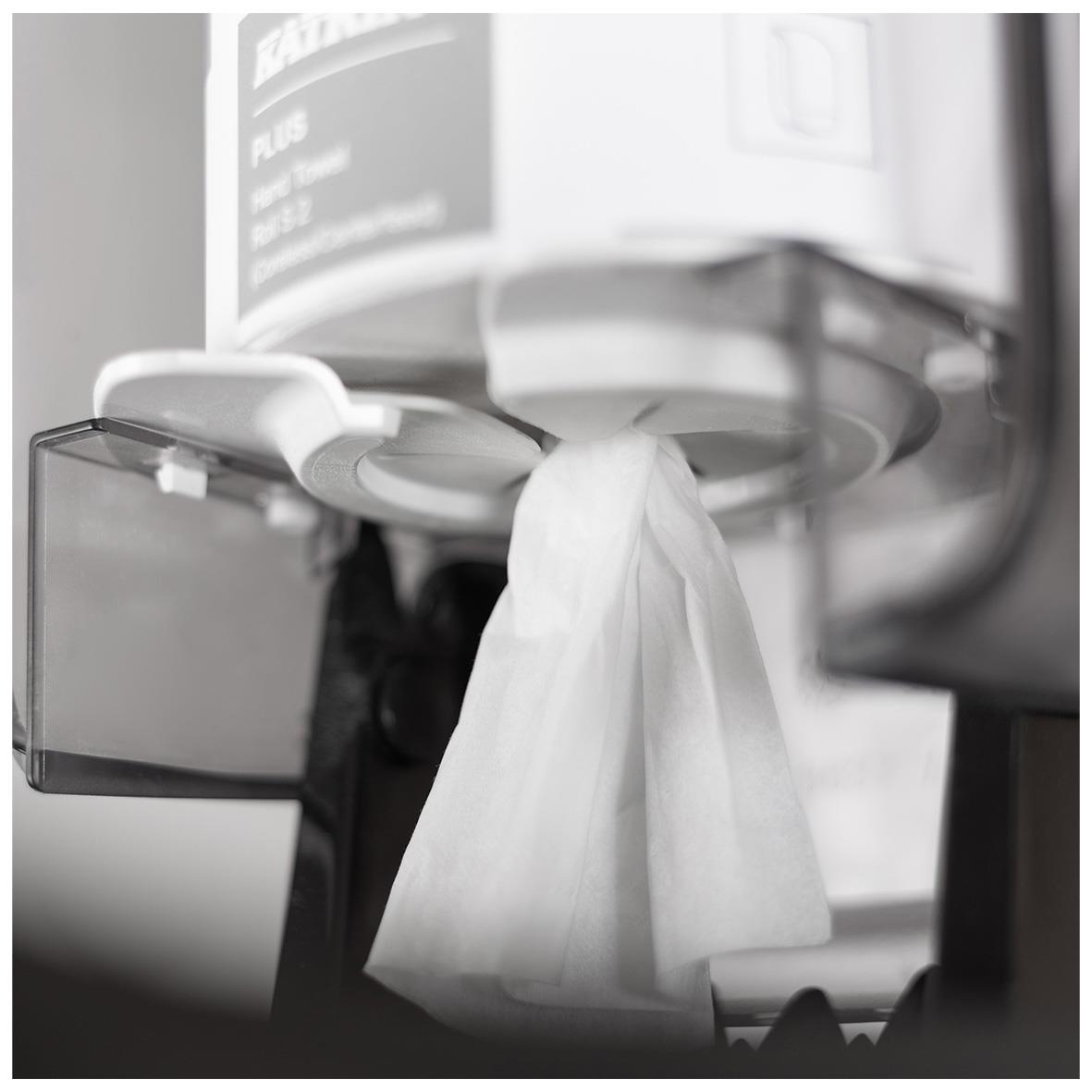 Dispenser för Katrin Centrummatad Torkrulle i vitt, med papper som hänger ut