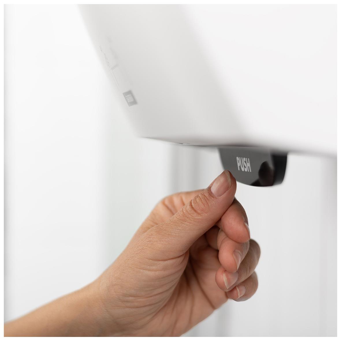 Hand som trycker på dispenser för pappershanddukar Katrin System M2 svart