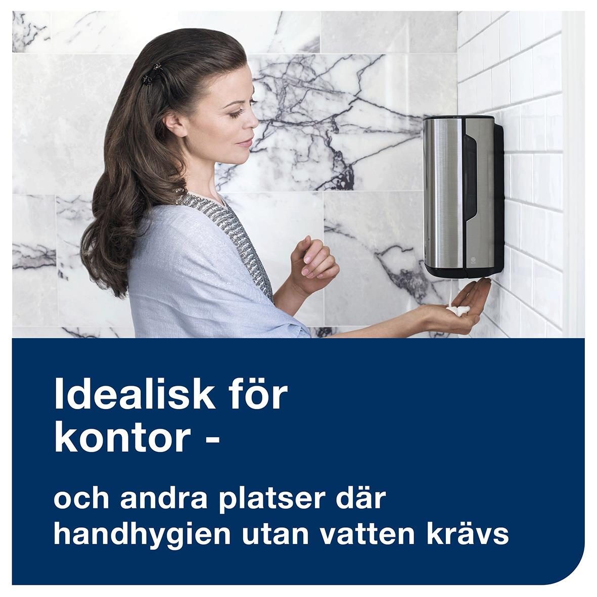 Kvinna använder handdesinfektionsskum Tork S4 alkohol 75 950ml på väggen