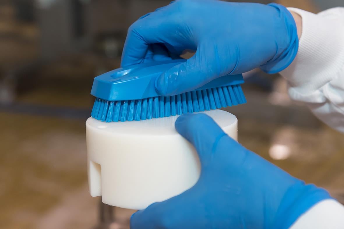 Hand- och nagelborste Vikan Hård Röd 130mm hålls av person i blå handskar