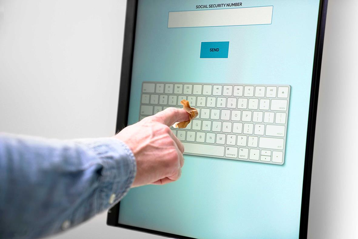 Person använder fingercover för att skriva på en digital skärm med ett tangentbord