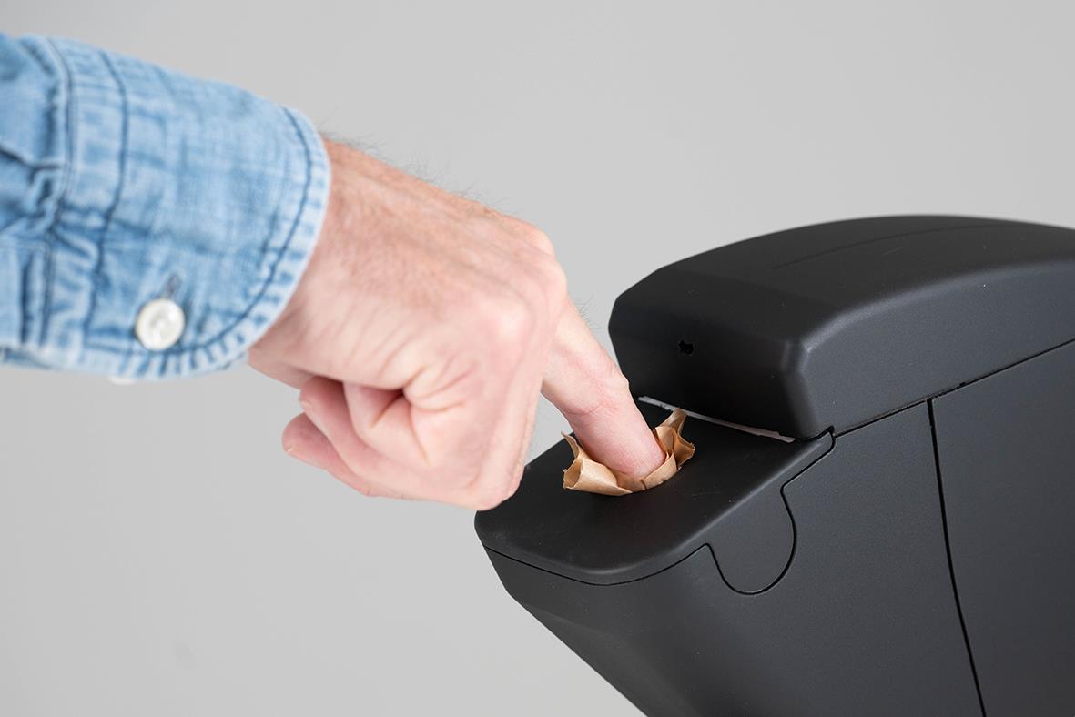 Person som trycker på väggfäste till svart dispenser