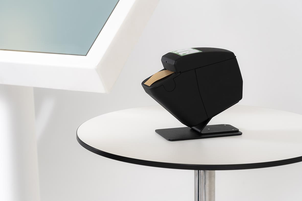 Svart bordsfäste till dispenser för papper på rund vit bord