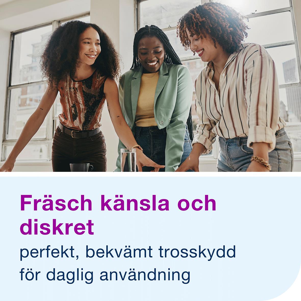 Tre kvinnor som ler och pratar tillsammans i ett kontorslandskap, främst fokus på text om Libresse Trosskydd