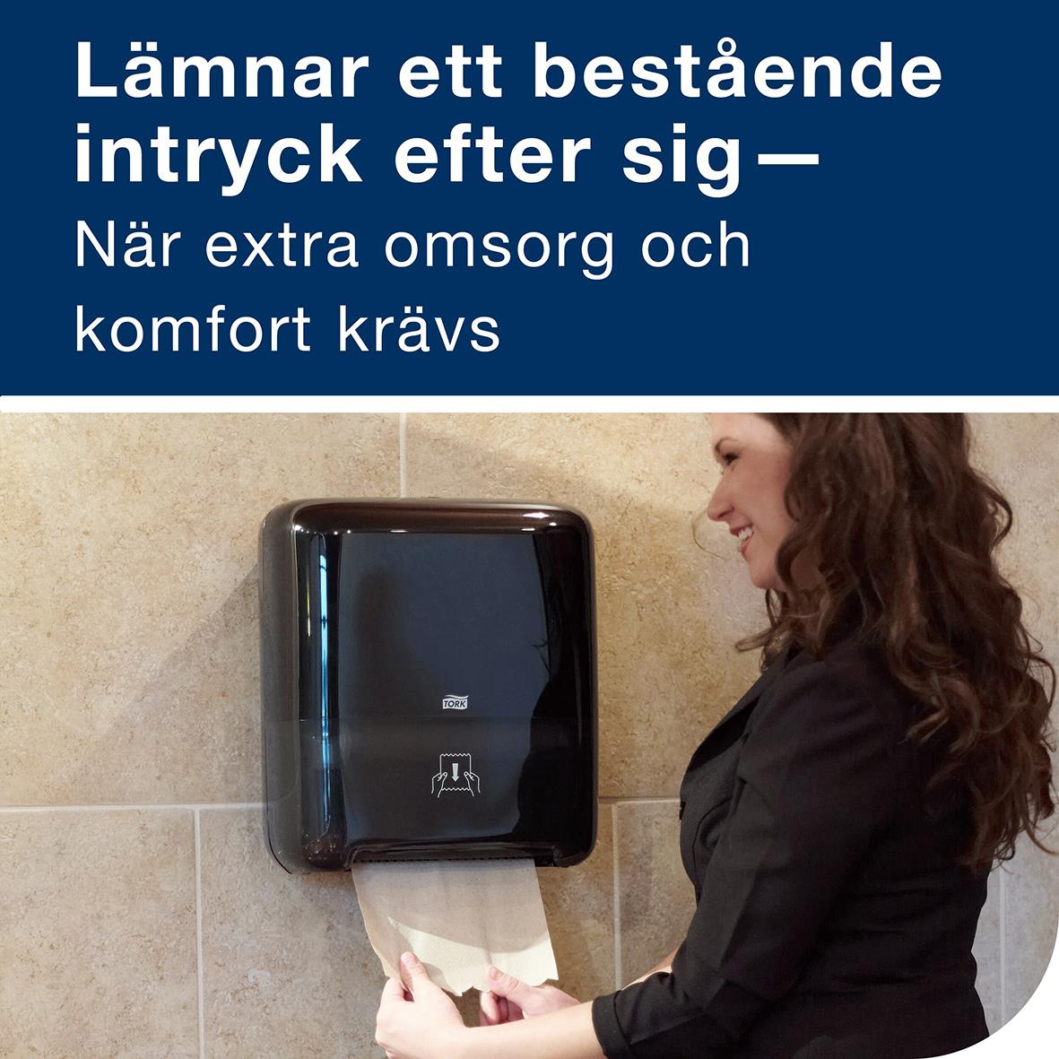 Kvinna använder pappershandduk från Tork H1 Matic Adv 2-lg Natur i offentligt utrymme