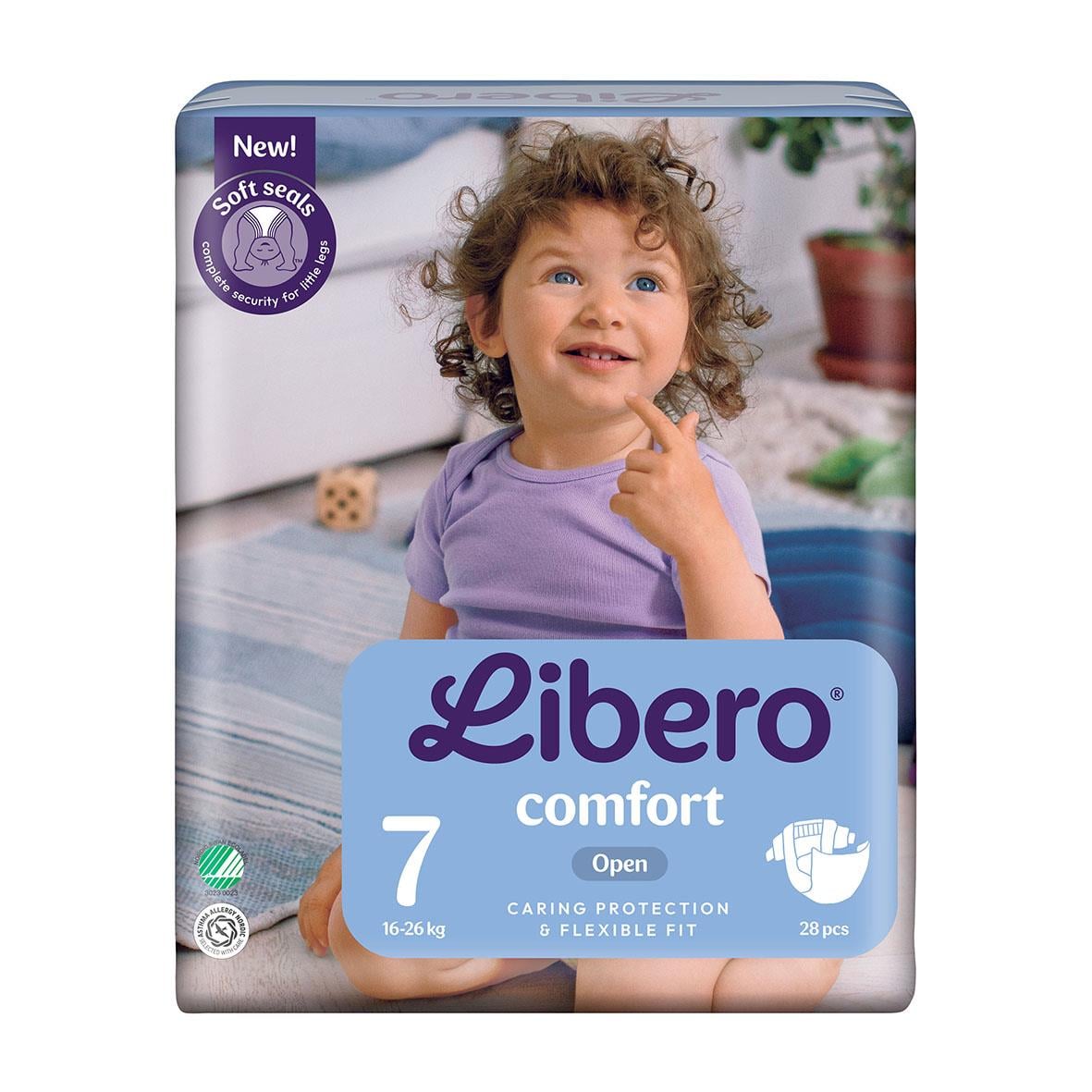 Barn i lila tröja med lockigt hår som ler och pekar på kinden, blöja Libero Comfort Size 7 16-26kg
