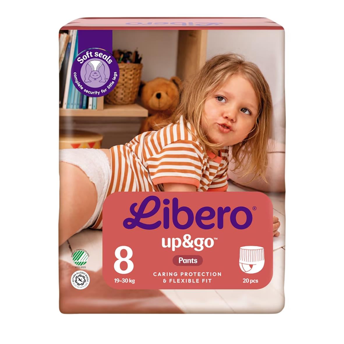 Barn i blöja Libero Up&Go Stl 8 19-30kg ligger på sidan i ett rum med leksaker och böcker i bakgrunden