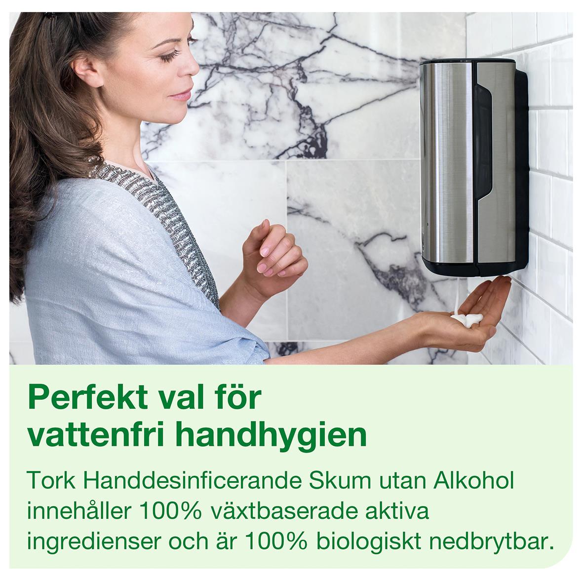 Kvinna använder handdesinfektion Tork S4 Skum utan alkohol på väggen