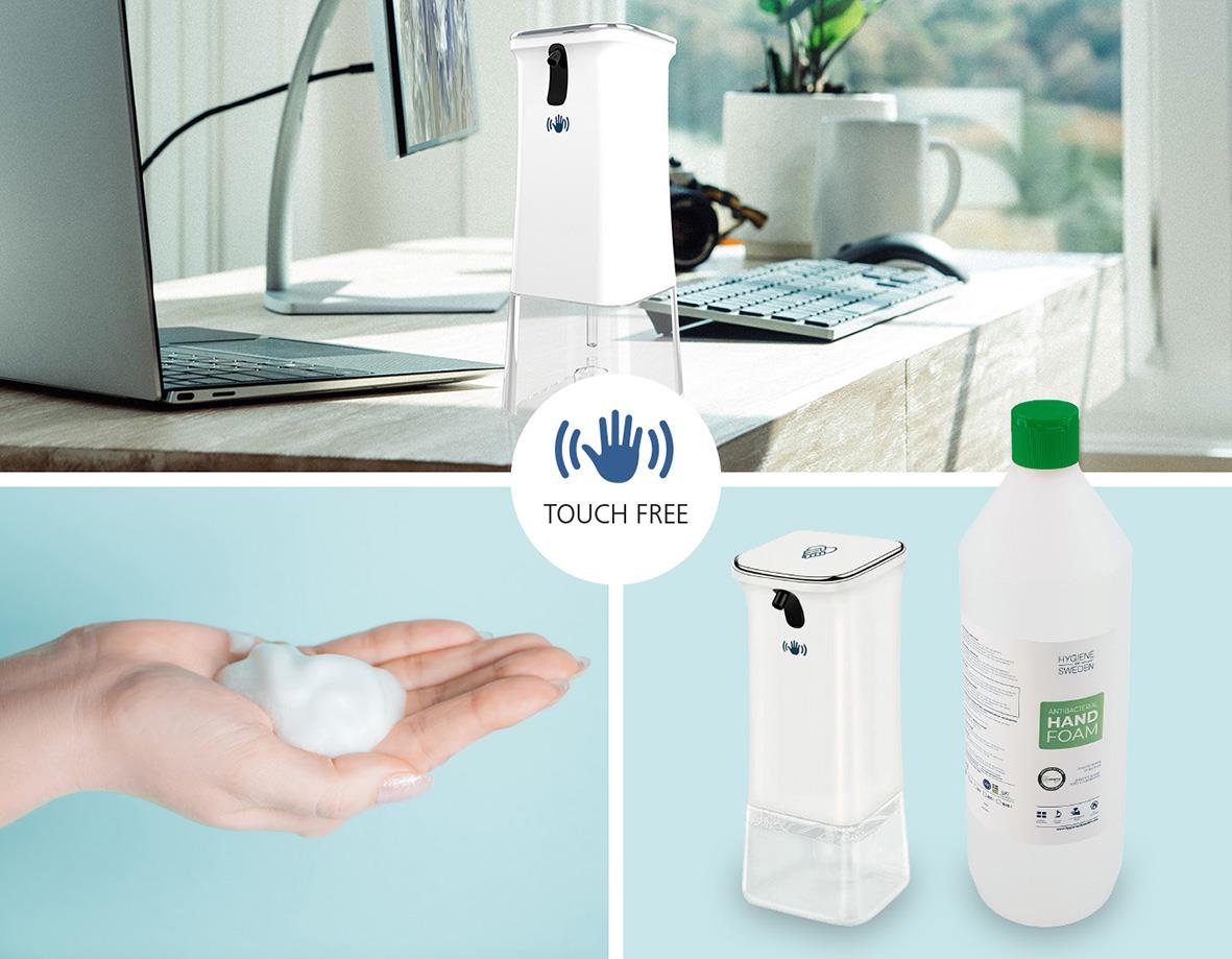 Touch-free handdesinfektionsdispenser på skrivbord med hand och tvålflaska i bakgrunden