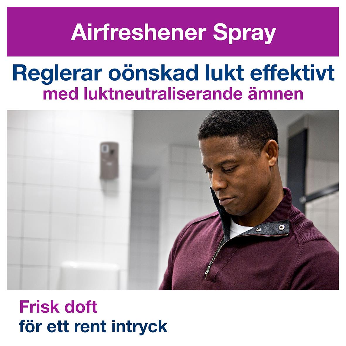Man använder Tork A1 luftfräschare dispenser i grå plast för att spraya frisk doft och neutralisera oönskad lukt