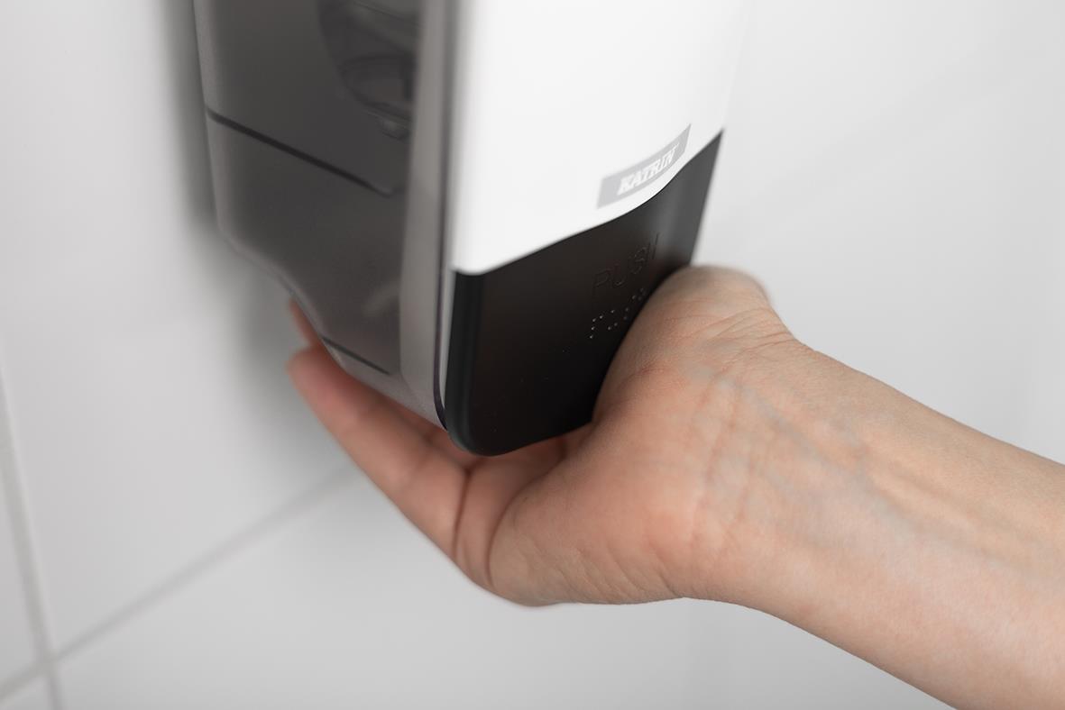 Hand som trycker på vit Katrin tvål dispenser 1000ml