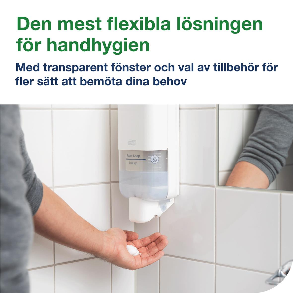 Vit plastdispenser Tork S4 monterad på vägg med person som använder den