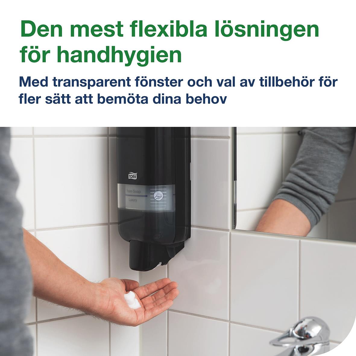 Svart plastdispenser Tork S4 monterad på vägg med person som använder den