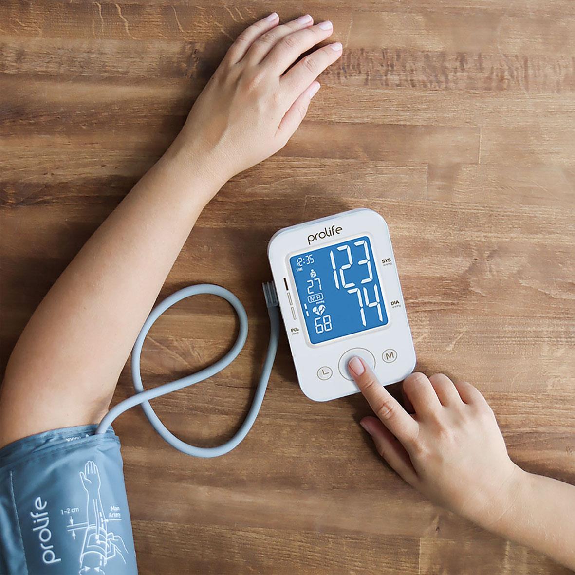 Blodtrycksmätare Prolife Digital PA2 Basic AD på ett bord med en hand som använder den