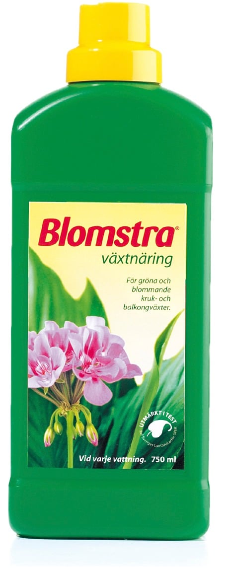 Grön plastflaska med gul topp och etikett med rosa blommor och text Blomstra växtnäring 750ml