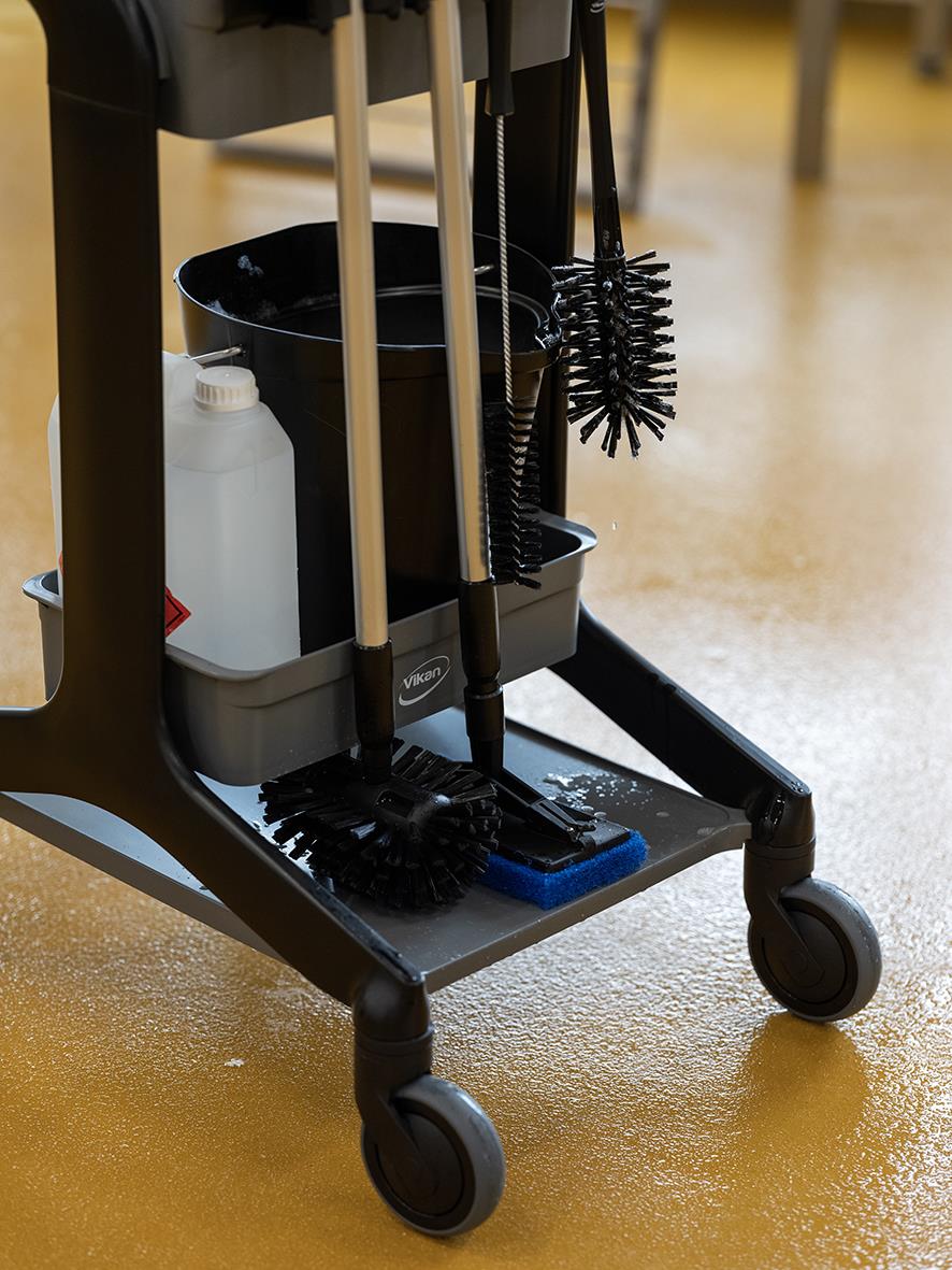 Rengöringsstation med moppar, borstar och rengöringsmedel på en vagn med hjul