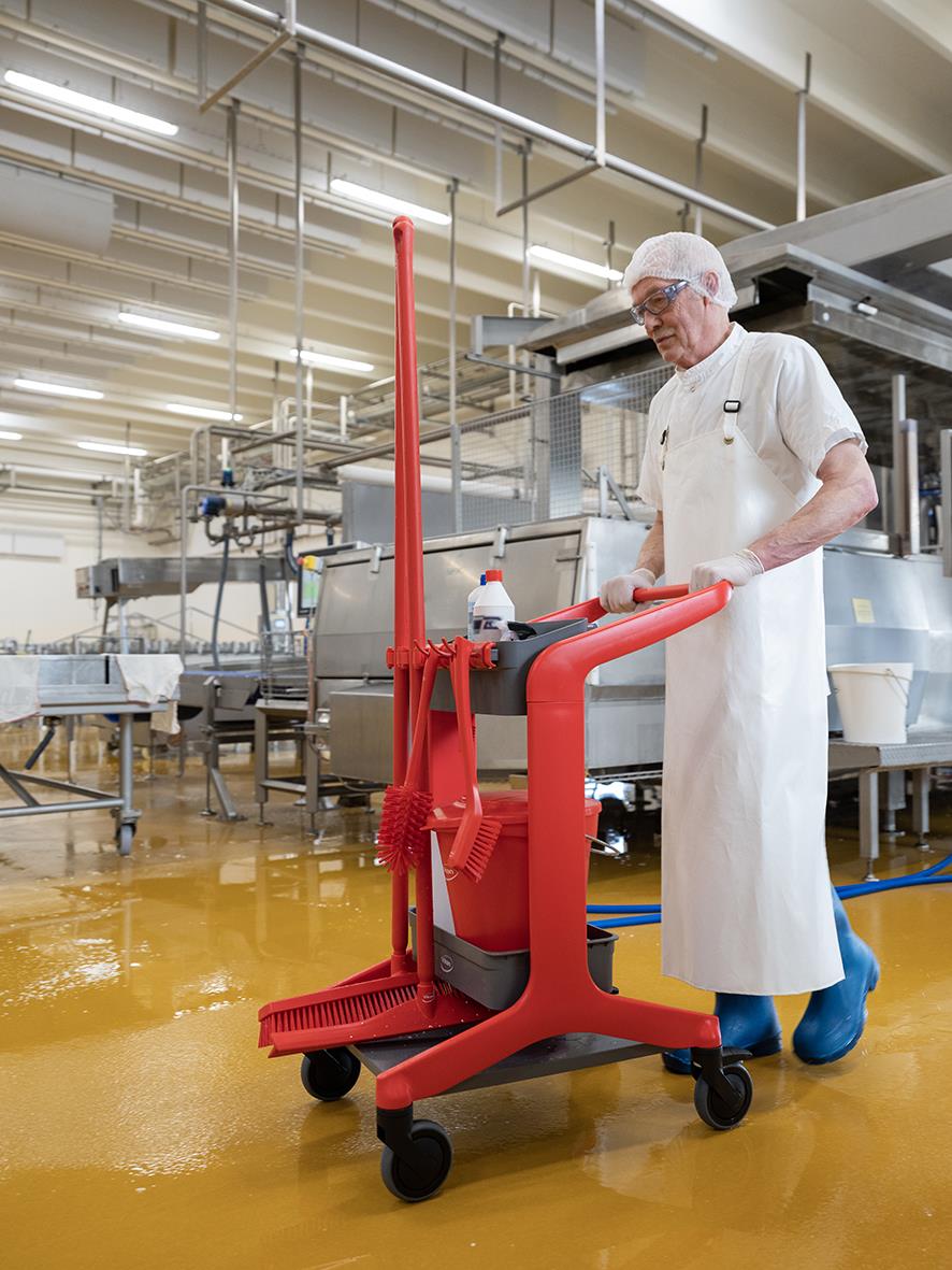 Person i skyddskläder använder rengöringsstation Vikan Hygo Grön i industriell miljö