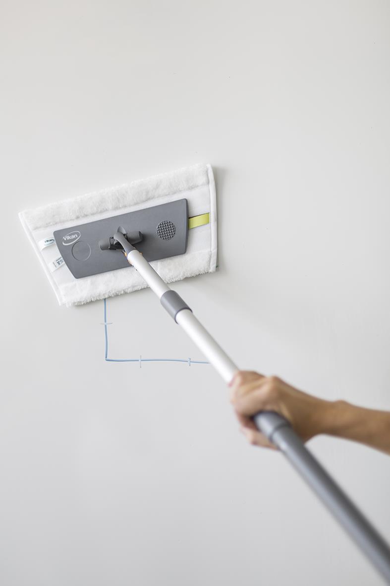 Person använder en Vikan tavelmopp 25cm för att torka en vägg