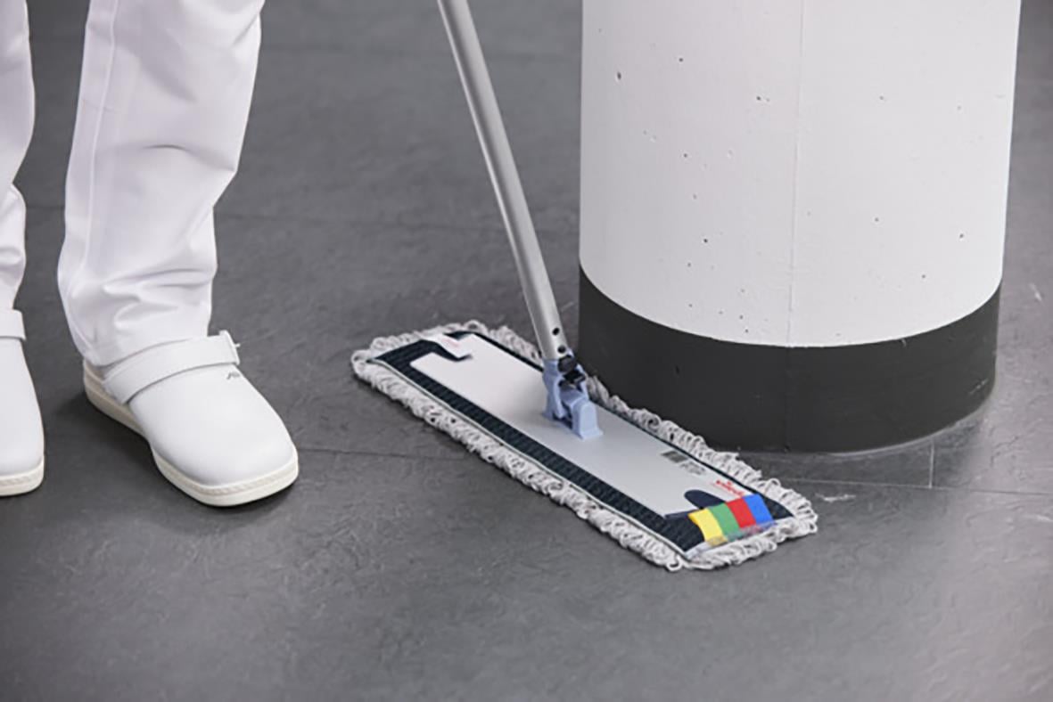 Kombimopp Vileda r-Trio Max 40cm används för att rengöra golv, med en person i vita skor som använder den.