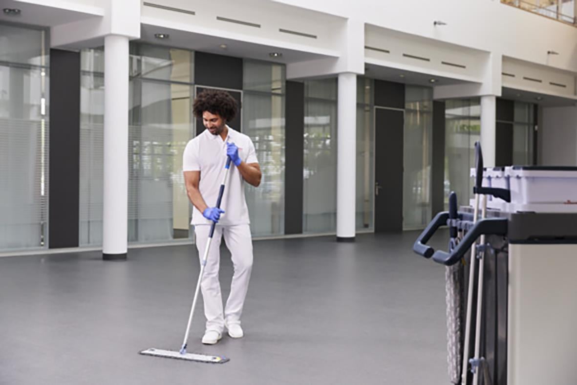 Man städar golv med Vileda kombimopp i en modern byggnad
