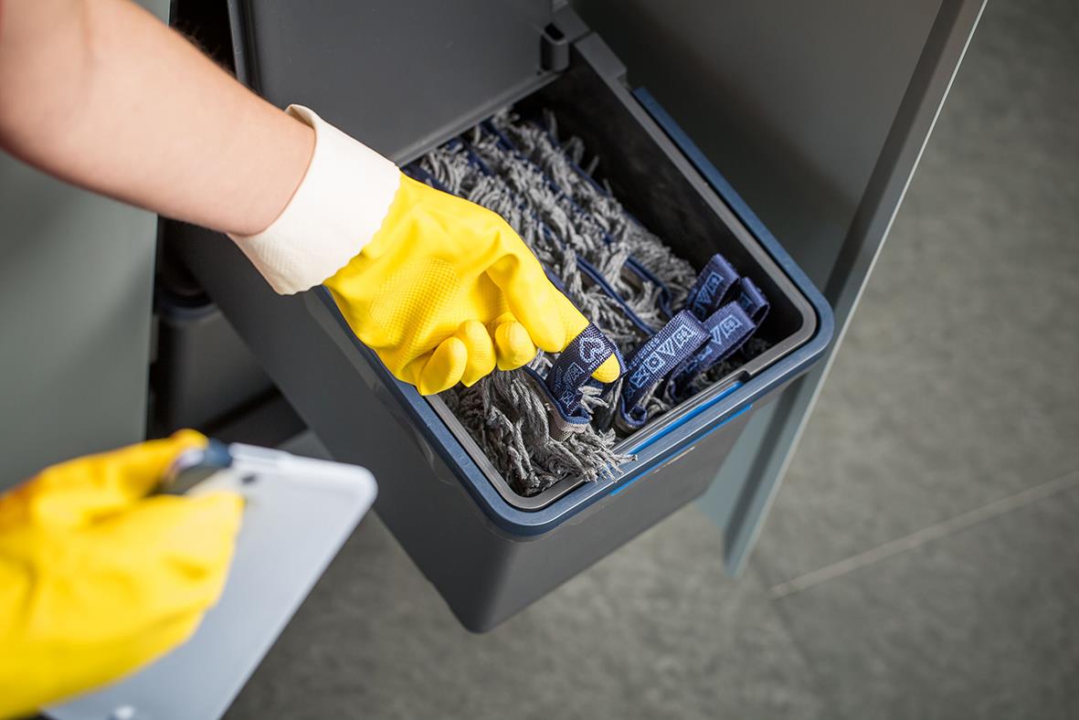 Person som rengör en Vileda Swep microtech mopp i en grå mopphink