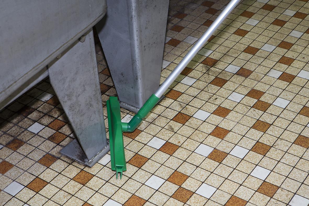 Golvskrapa Vikan Hygien med utbyteskasett och vridbar handtag på golv med små rutmönster