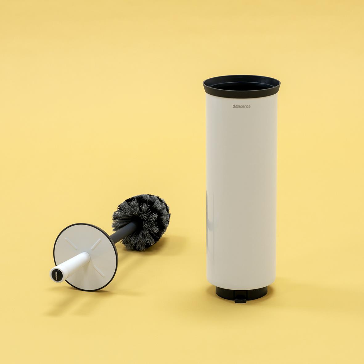 Toalettborste Brabantia Profile med vit hållare och borste på gul bakgrund