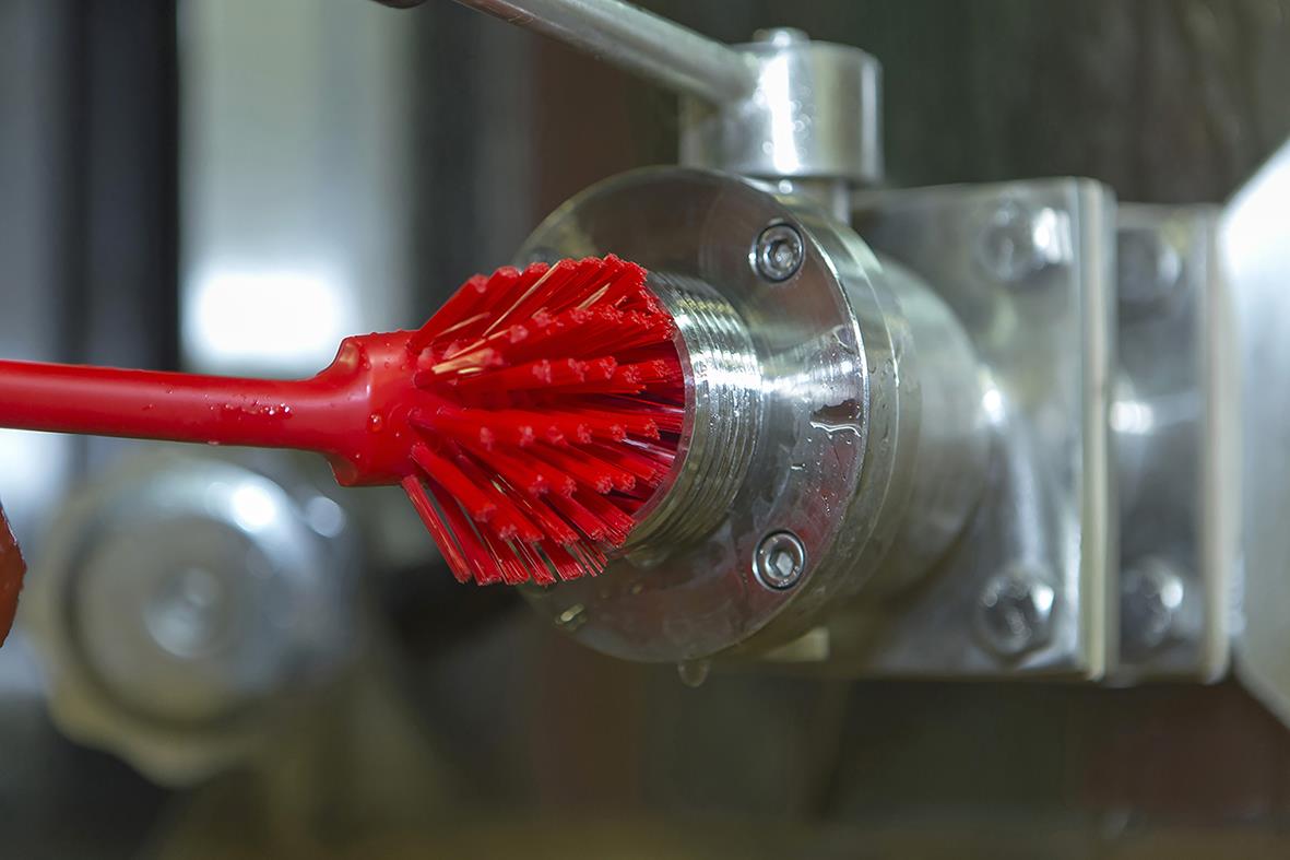 Röd diskborste Vikan Medium 280mm som rengör en metallrulle