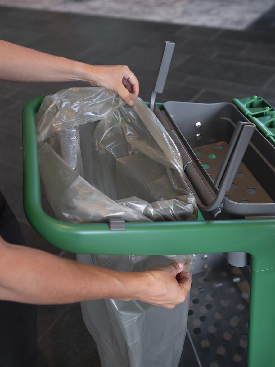 Person placerar sopsäck i Vikan sopsäckshållare på Hygo rengöringsstation