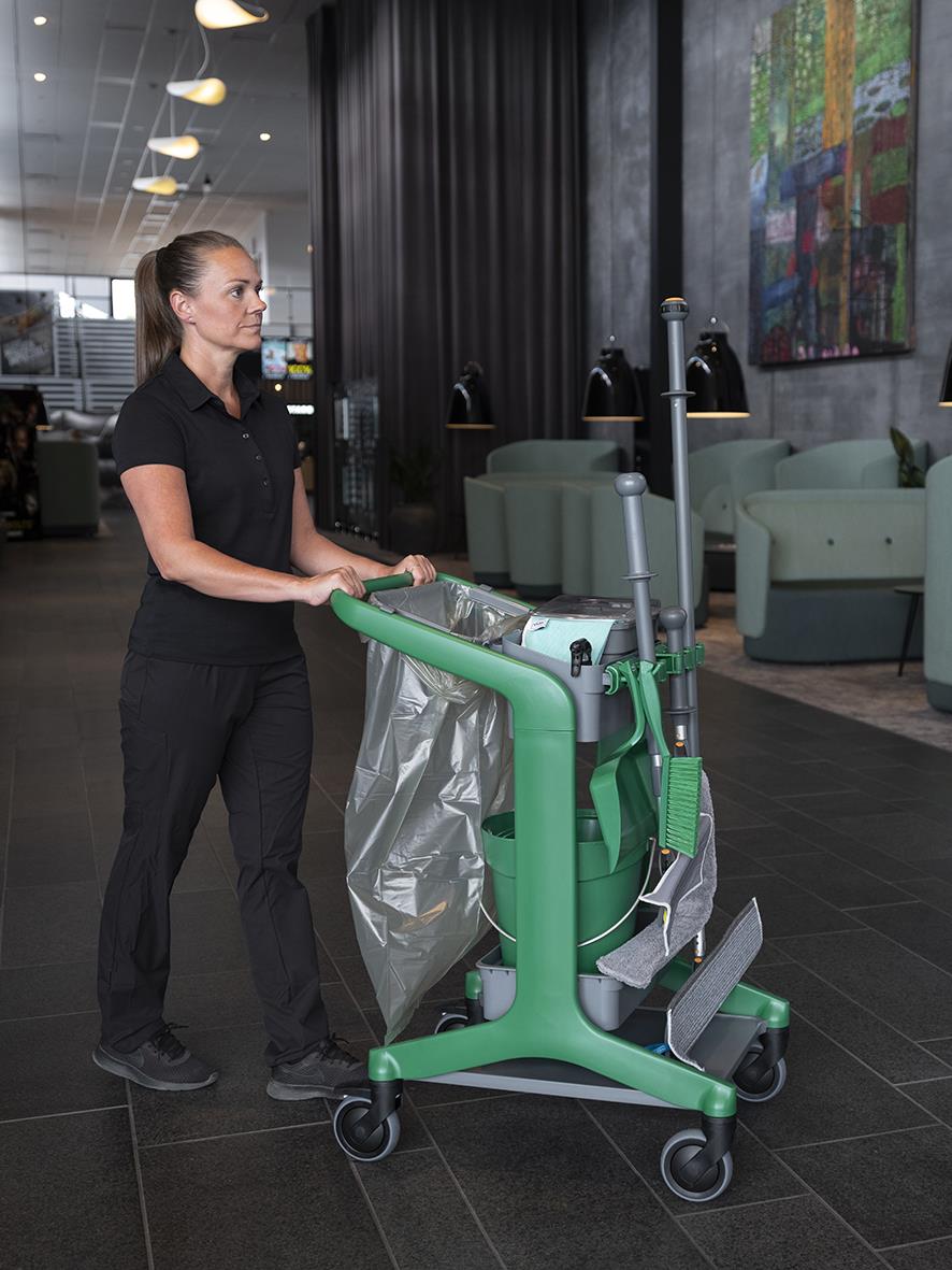Kvinna med sopsäckshållare Vikan på rengöringsstation i lobby