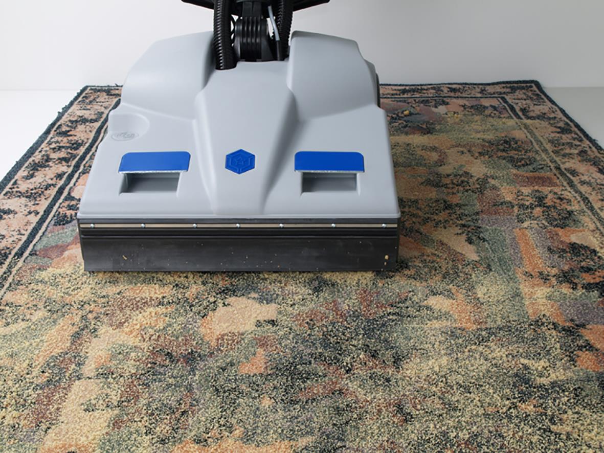 Borstvalsdammsugare Lindhaus LS 50 som rengör ett gammalt matta