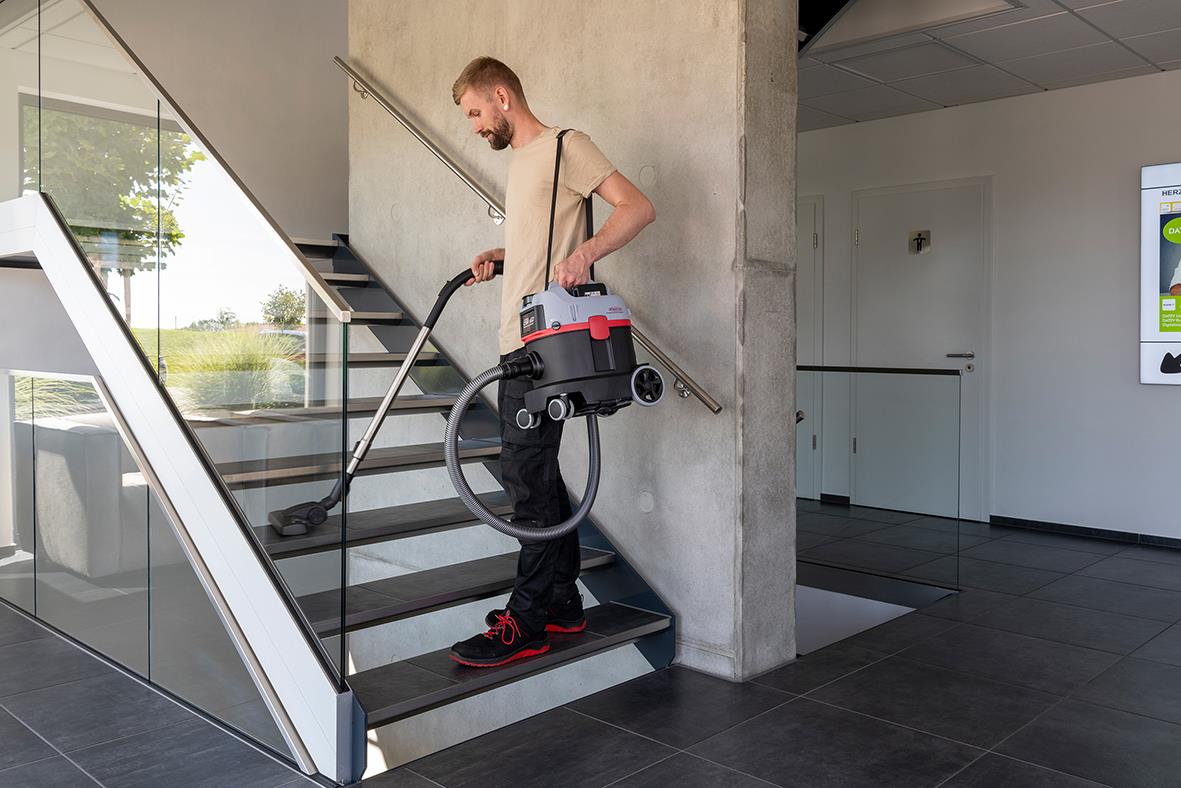 Man använder Dammsugare Sprintus iGO batteridriven för att städa trappor inomhus