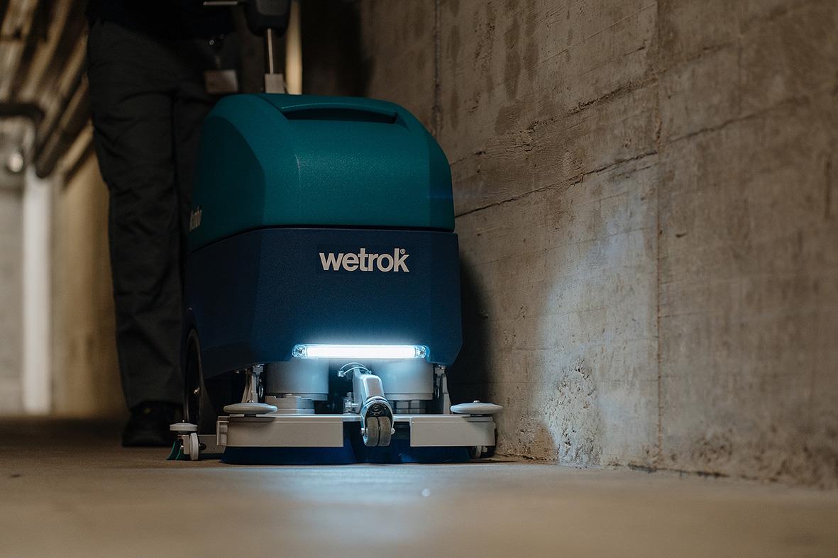 Kombiskurmaskin Wetrok Mambo med autodosering och Li-Batteri på golvet i en industrimiljö