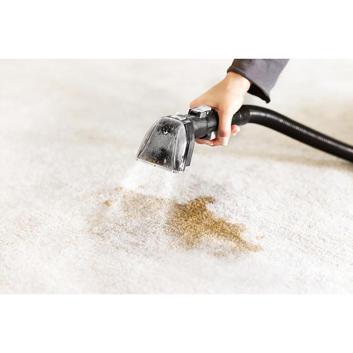 Person som använder Bissell Spotclean Hydrosteam Pro för att rengöra en matta