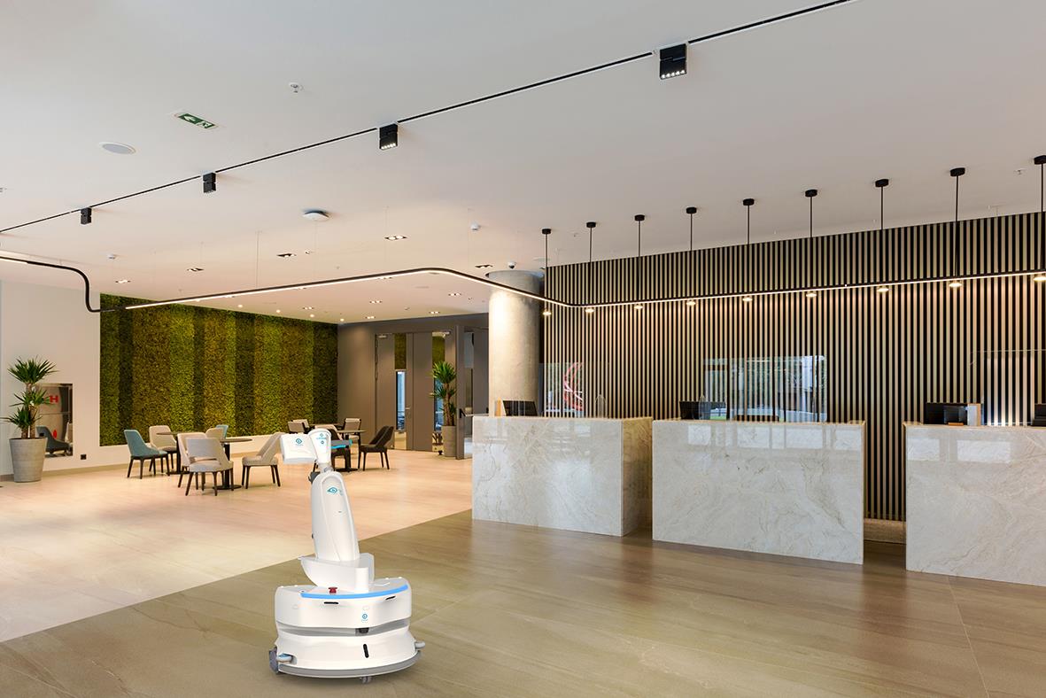 Robothandlar i ett modernt hotellreceptionområde med sittplatser och gröna växter