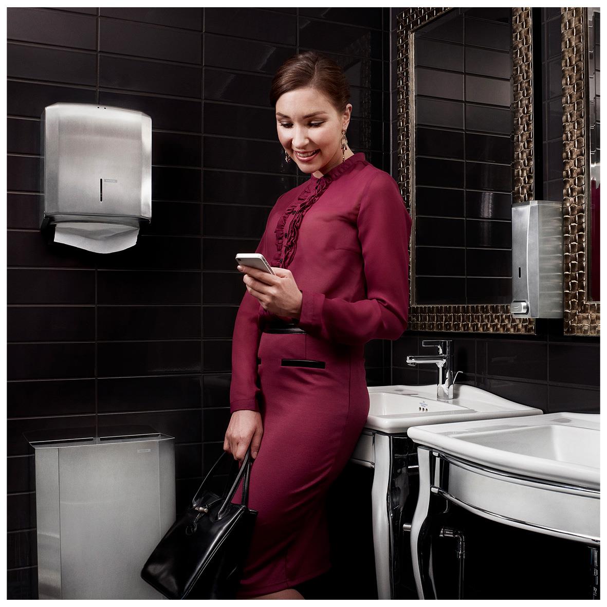 Kvinna i mörkröd klänning i badrum med rostfri papperskorg 25L