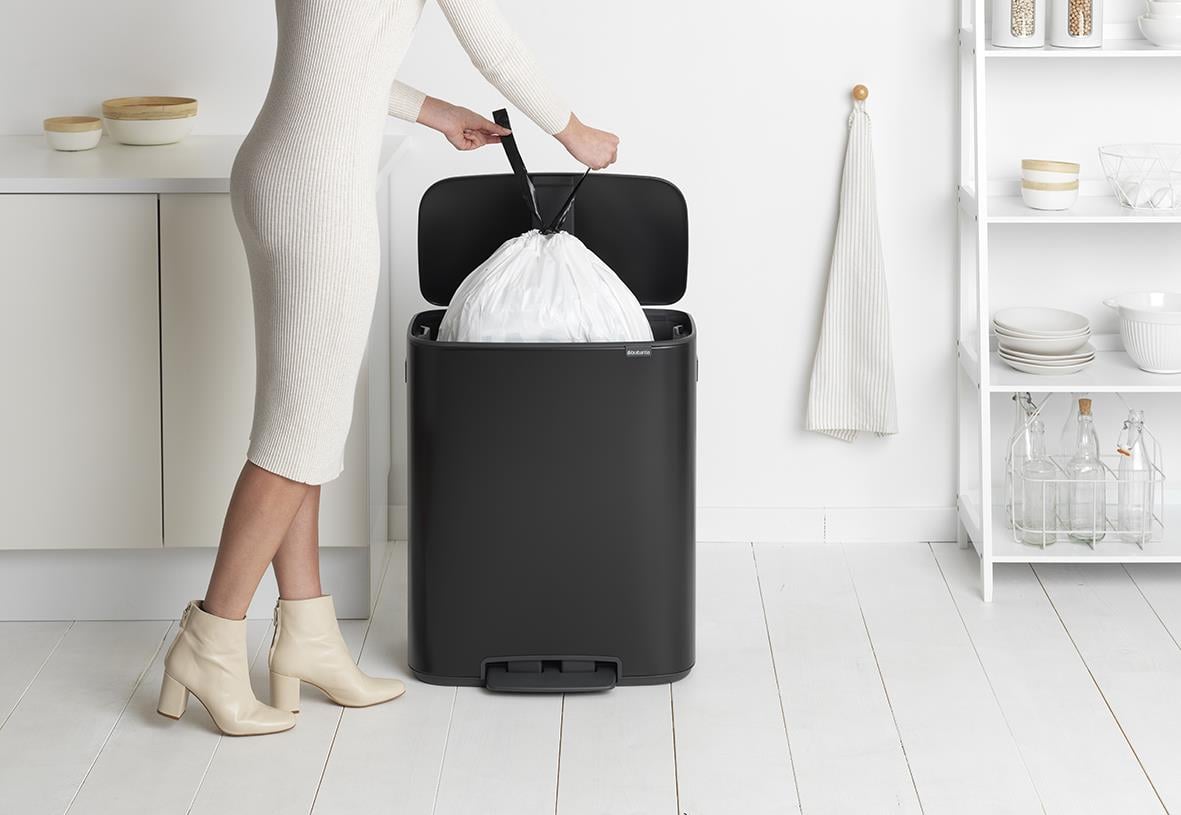 Person som tömmer en svart Brabantia Bo Matt pedalhink med 60L kapacitet i ett kök