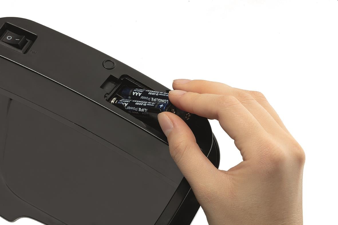 Hand som byter batteri i en silverfärgad papperskorg med sensorstyrning