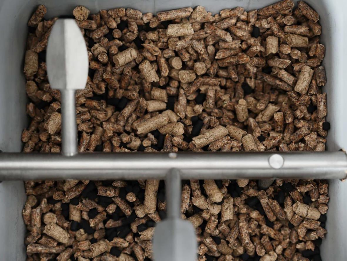 Kompoststartare Reencle Prime med bruna kompostbitar i en behållare