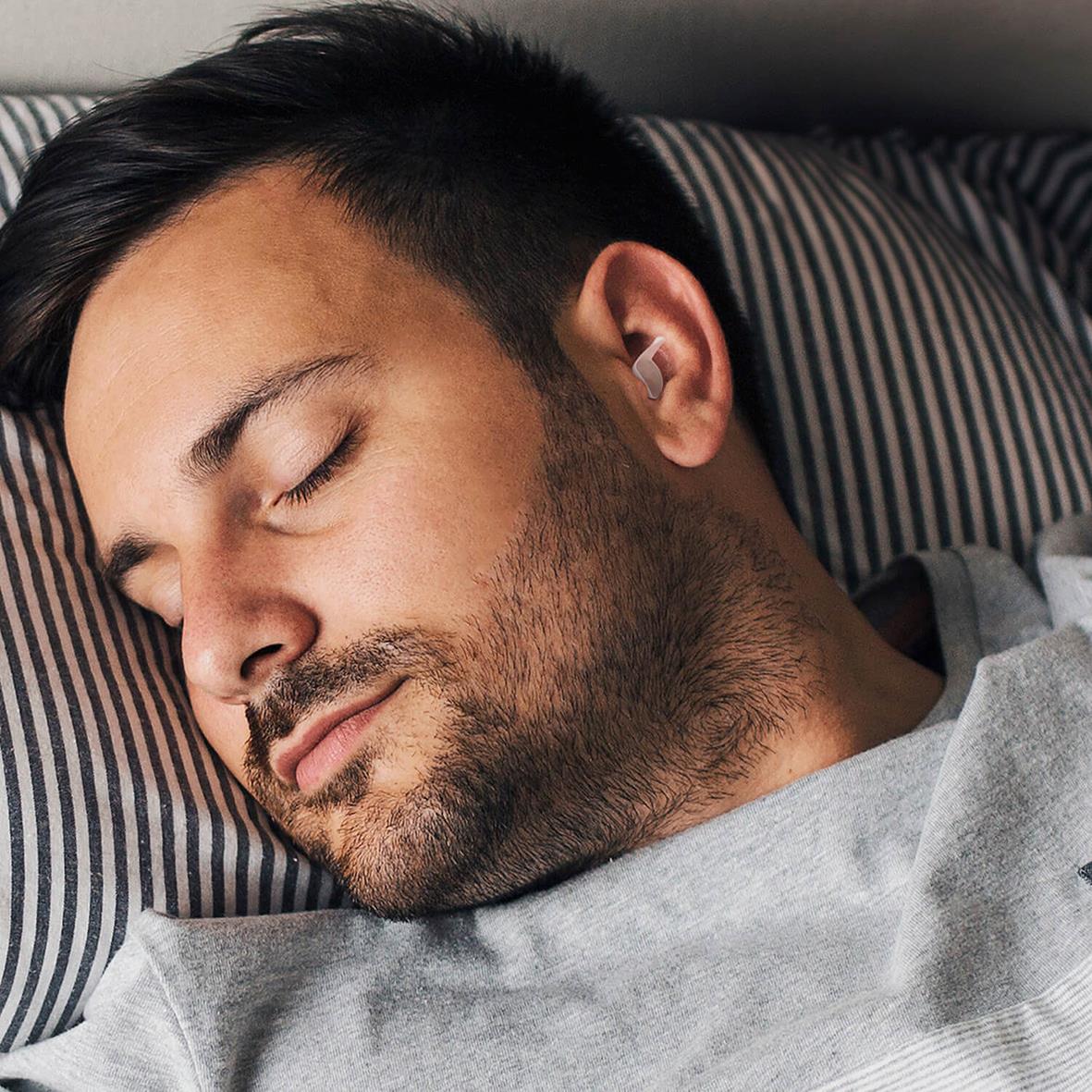 Man som sover med hörselskydd Mixx Noise Protection Sleep i öronen