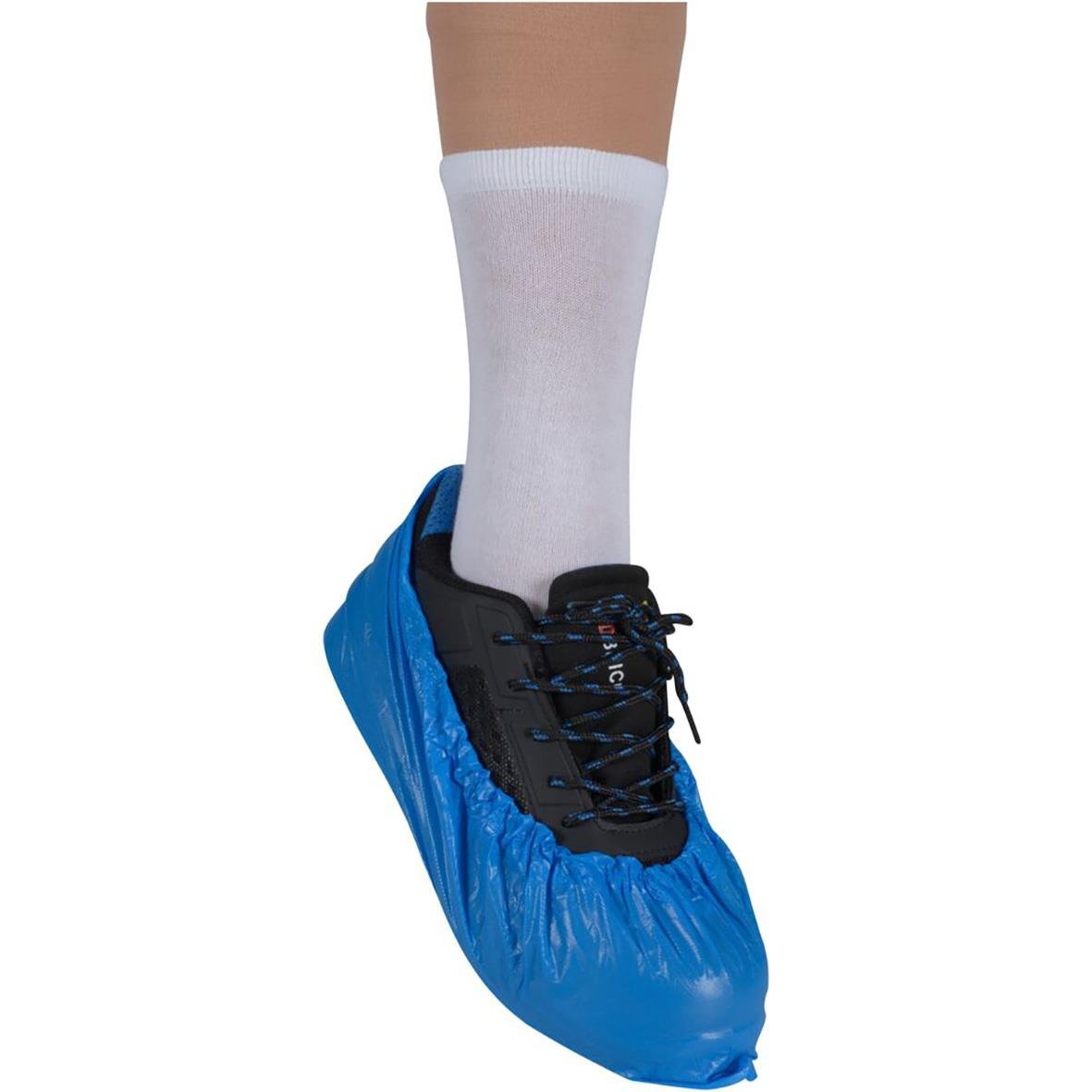 Person med vit socka och blå skoskydd på en svart sko