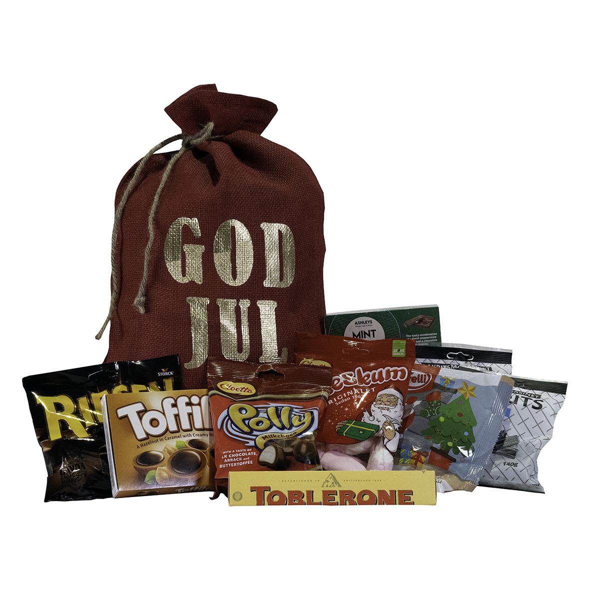 Röd jutesäck med julhälsning och godis framför