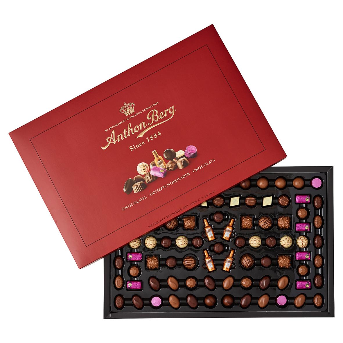 Röd låda med Anthon Berg Diplomat choklad 1kg, öppnad för att visa olika praliner och chokladbitar