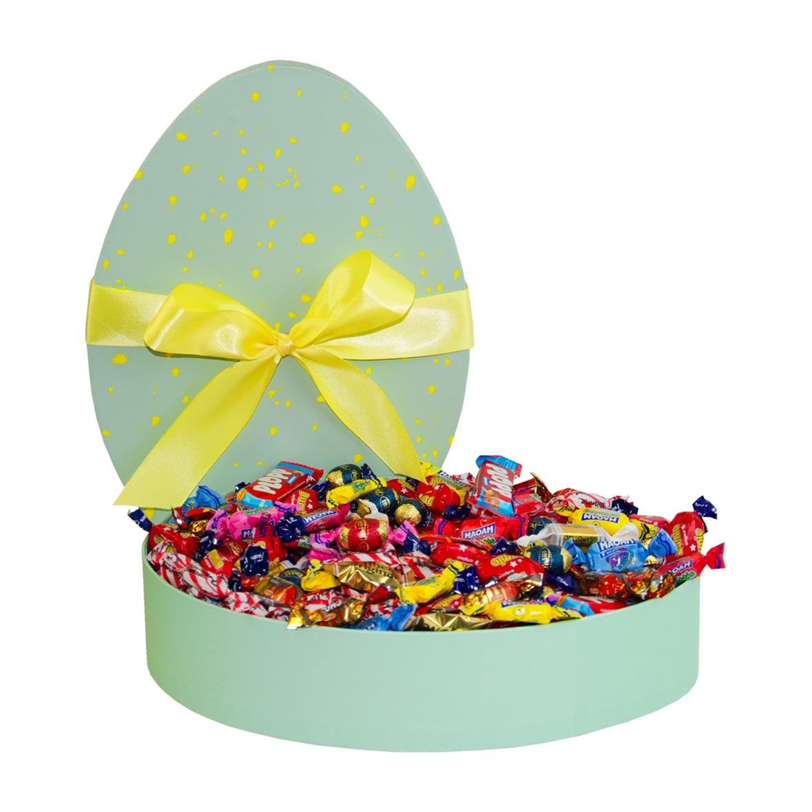 Påskägg fylld med godis, öppnat med många färgglada godisbitar i en rund låda