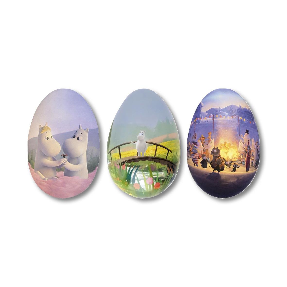 Påskägg med tre Muminmotiv och godis i en grön skål