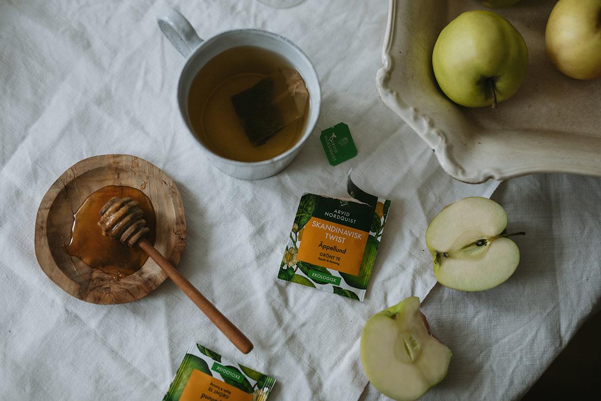 Grönt te från Arvid Nordquist Äppellund med äpplen och honung på ett vitt tyg