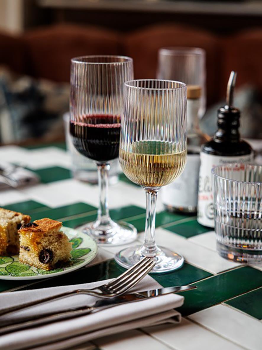 Vinglas av polykarbonat med randig design, ett med rödvin och ett med vitt vin, på dukad bord