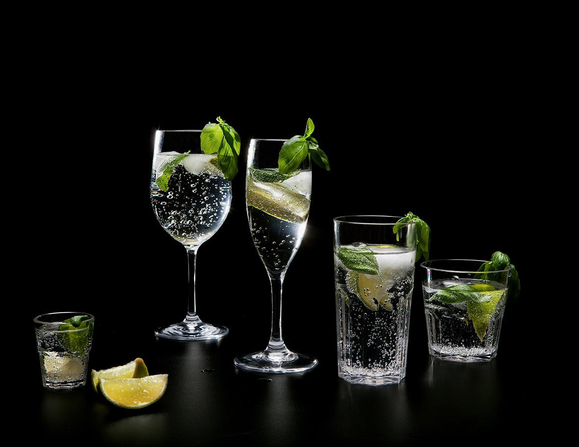 Fyra olika drinkglas av Tritan BPA-fritt, med citron- och myntdekorationer, mot svart bakgrund