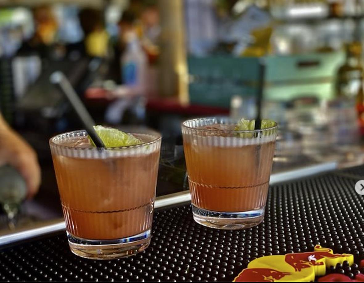 Två drinkglas med stripe-mönster och limeklyftor på en bar