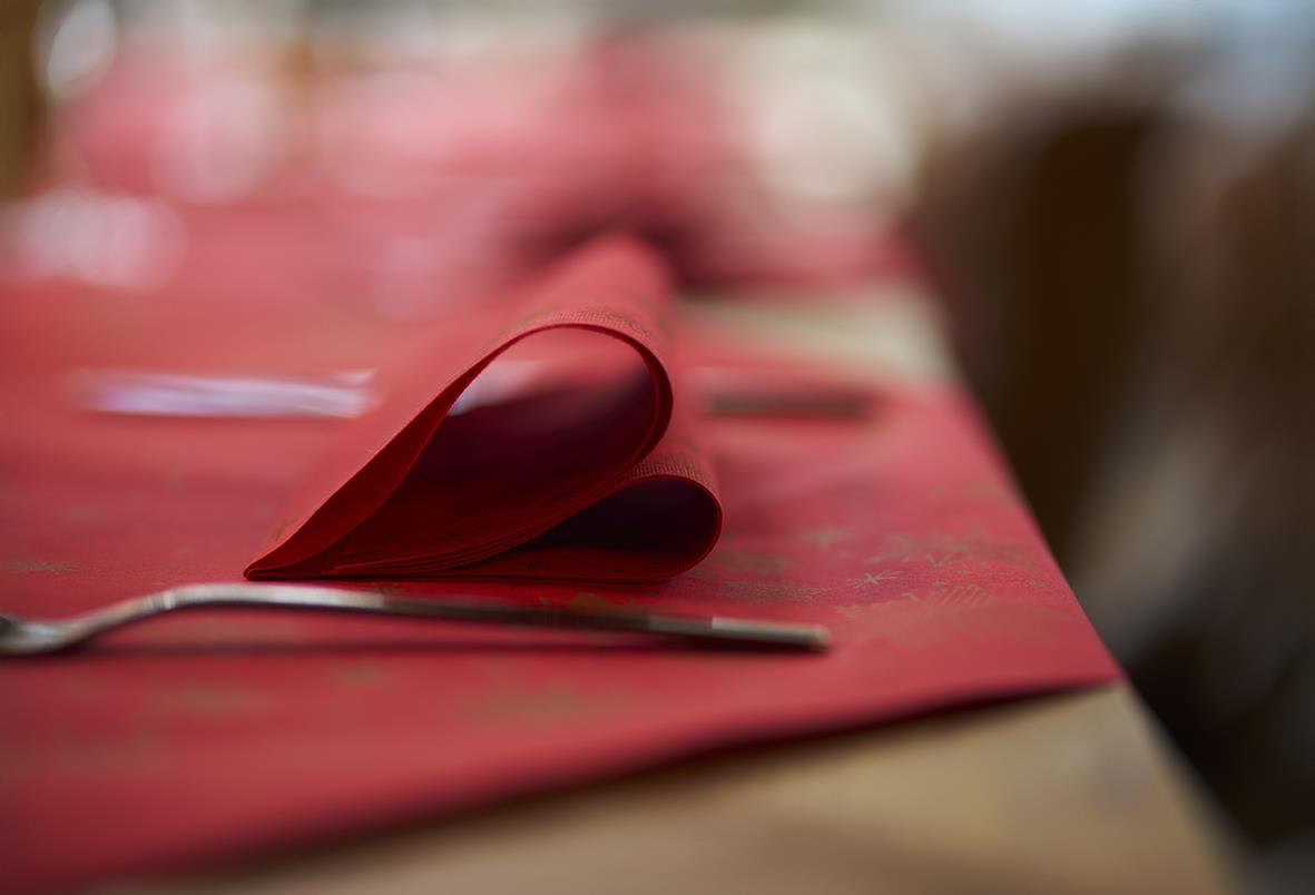 Röd snibbduk Duni Stargazing Dunisilk på bord med fokus på hörnet